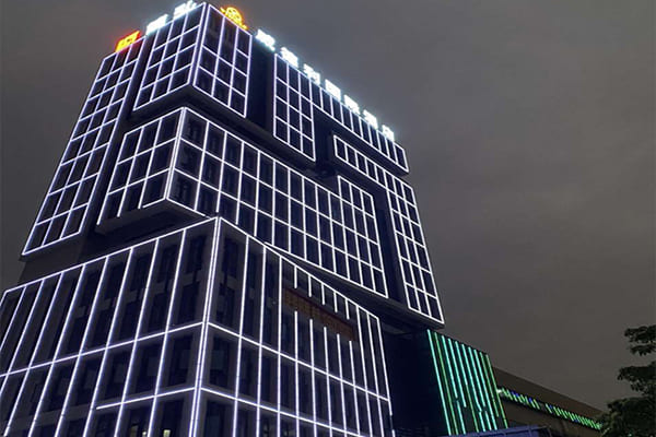 A modern office building with its edges defined by linear LED lighting